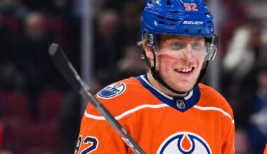Patrik Laine smiling while wearing an Edmonton Oilers home jersey and blue helmet with visor, visualizing free agency rumors linking him to the Oilers.