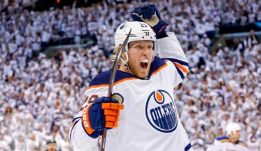 Conceptual action photo of NHL player Patrik Laine celebrating wildly in an Edmonton Oilers white away jersey and helmet, illustrating potential Free Agency landing spots for the pending UFA.
