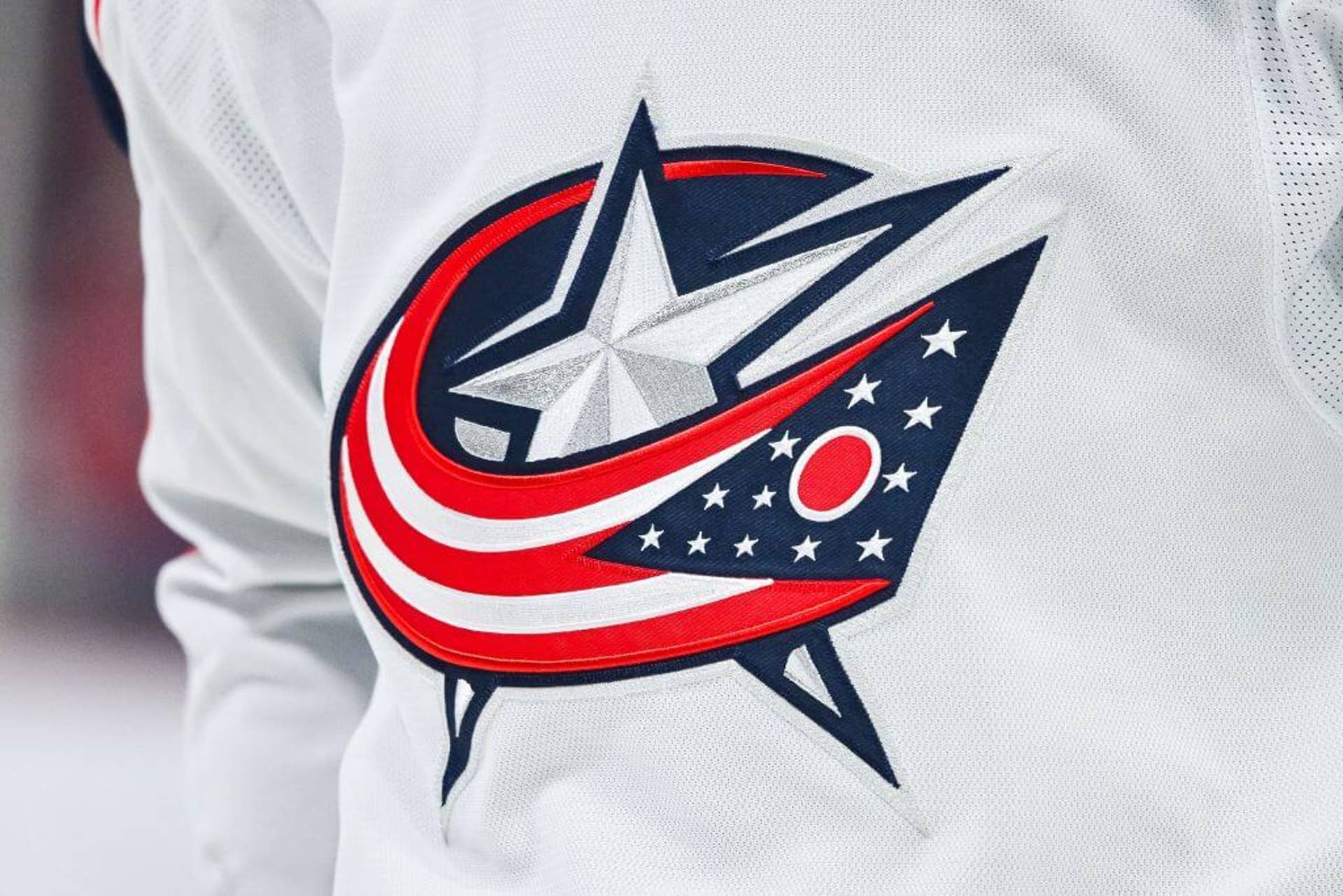 View of a Columbus Blue Jackets logo on a warmup jersey worn by a member of the team.