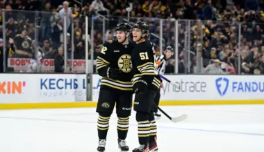 Boston Bruins center Matthew Poitras (51) celebrates a goal against the New York Rangers with defenseman Reilly Walsh (92) during the first period at TD Garden.