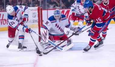 New York Rangers defenseman Adam Fox (23) battles with Montreal Canadiens center Alex Newhook (15) for control of the puck in the second period at the Bell Centre.