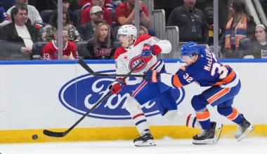Montr&eacute;al Canadiens defenseman David Reinbacher (64) passes the puck as New York Islanders center Kyle MacLean (32) chases in the second period at UBS Arena.