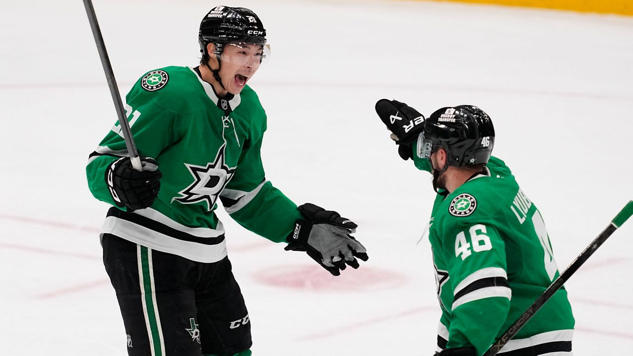 Dallas Stars left wing Jason Robertson (21) and Ilya Lyubushkin (46) celebrate after Robertson scored in the third period of an NHL hockey game against the Minnesota Wild Thursday, April 9, 2026, in Arlington, Texas. (AP Photo/Tony Gutierrez)