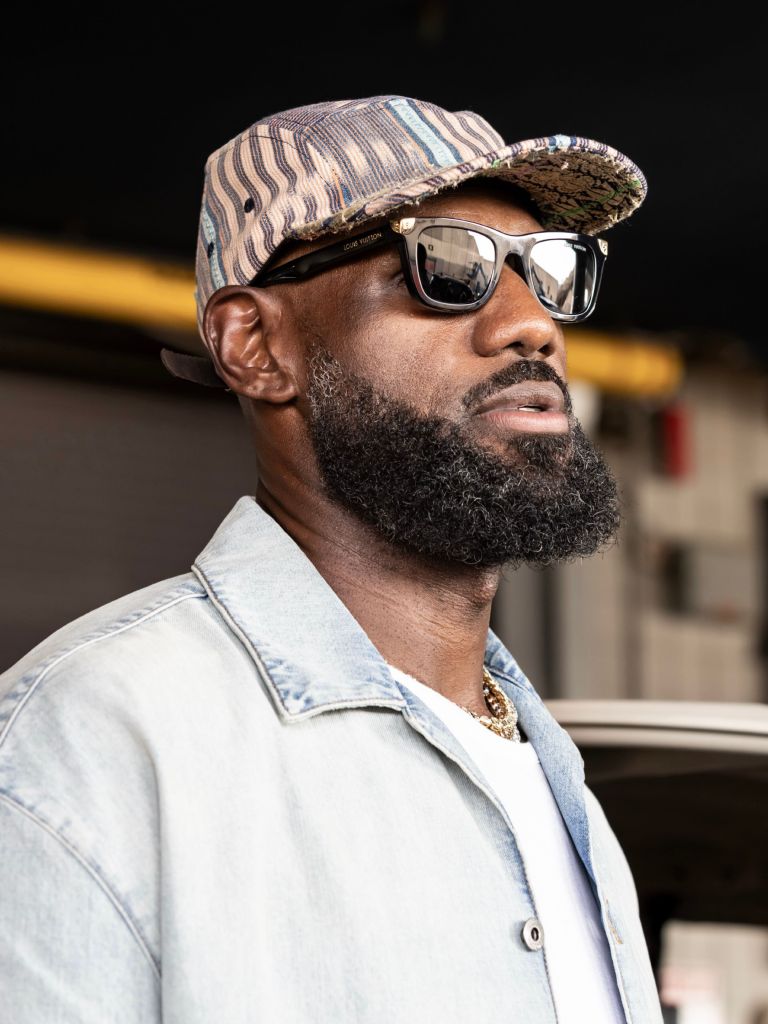 LeBron James wearing a striped hat and sunglasses, a denim jacket, and a gold chain.