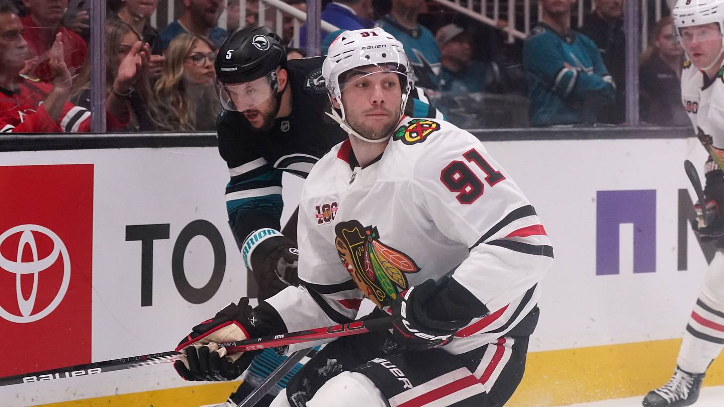 Apr 6, 2026; San Jose, California, USA;  Chicago Blackhawks center Frank Nazar (91) and San Jose Sharks defenseman Vincent Desharnais (5) chase the puck in the first period at SAP Center at San Jose. Mandatory Credit: David Gonzales-Imagn Images