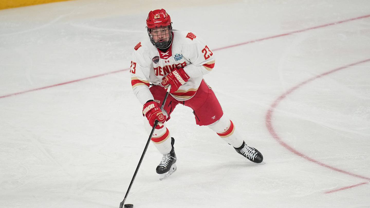 Apr 11, 2026; Las Vegas, Nevada, United States; Denver Pioneers defenseman Eric Pohlkamp (23) skates up the ice with the puck during the first period against the Wisconsin Badgers in the championship game of the NCAA men's ice hockey Frozen Four at T-Mobile Arena. Mandatory Credit: Lucas Peltier-Imagn Images