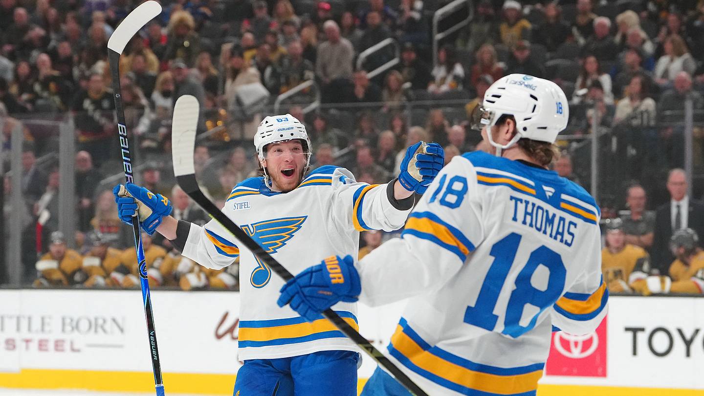 Jan 10, 2026; Las Vegas, Nevada, USA; St. Louis Blues left wing Jake Neighbours (63) celebrates a goal scored against the Vegas Golden Knights by center Robert Thomas (18) during the first period at T-Mobile Arena. Mandatory Credit: Stephen R. Sylvanie-Imagn Images