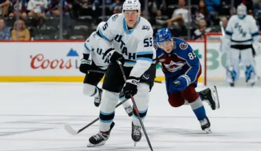 Utah Mammoth defenseman Maksymilian Szuber (55) controls the puck ahead of Colorado Avalanche center Nikita Prishchepov (85) in the third period at Ball Arena.