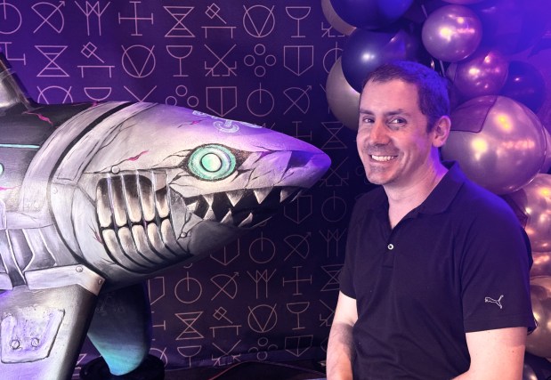 David Faria, director of operations at Guildhouse, poses next to "Fishbones," an art shark painted by Cindy Duong, during Guildhouse's fifth anniversary celebration in downtown San Jose on Thursday, July 30, 2026. (Sal Pizarro/Bay Area News Group)