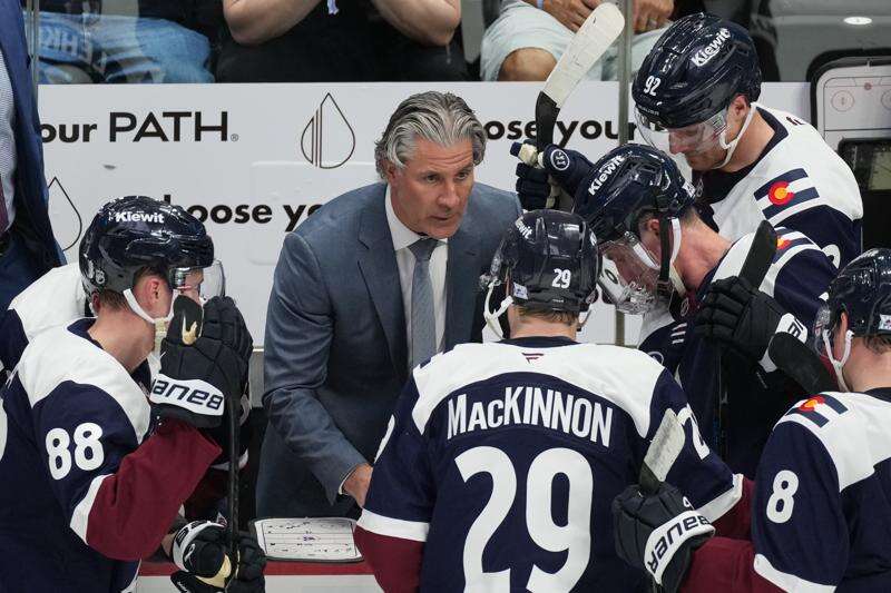 FILE - Colorado Avalanche head coach Jared Bednar, center, draws up a play during a time out in the third period of an NHL hockey game against the Minnesota Wild, Feb. 26, 2026, in Denver. (AP Photo/David Zalubowski, File)