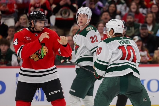 Blackhawks defenseman Wyatt Kaiser (44) and Wild right wing Bobby Brink (10) fight during the second period of the Blackhawks preseason opener at the United Center Sept. 21, 2026 in Chicago. (Armando L. Sanchez/Chicago Tribune)