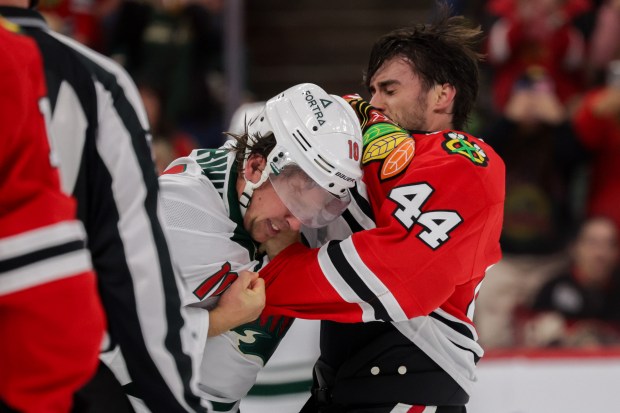 Blackhawks defenseman Wyatt Kaiser (44) and Wild right wing Bobby Brink (10) fight during the second period of the Blackhawks preseason opener at the United Center Sept. 21, 2026 in Chicago. (Armando L. Sanchez/Chicago Tribune)
