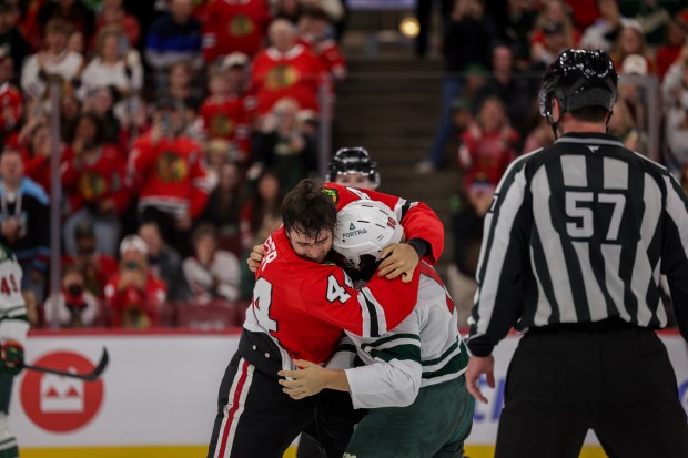Blackhawks defenseman Wyatt Kaiser (44) and Wild right wing Bobby Brink (10) fight during the second period of the Blackhawks preseason opener at the United Center Sept. 21, 2026 in Chicago. (Armando L. Sanchez/Chicago Tribune)