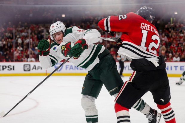 Blackhawks left wing Jordan Greenway (12) hits Wild center Charlie Stramel (15) during the third period of the Blackhawks preseason opener at the United Center Sept. 21, 2026 in Chicago. (Armando L. Sanchez/Chicago Tribune)