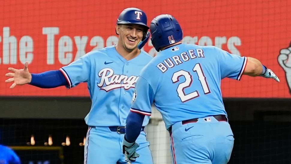Texas Rangers' Wyatt Langford, left, and Jake Burger (21) celebrate Burger's two-run home run that scored Langford during the fourth inning of a baseball game against the Tampa Bay Rays Sunday, Sept. 6, 2026, in Arlington, Texas. (AP Photo/Tony Gutierrez)