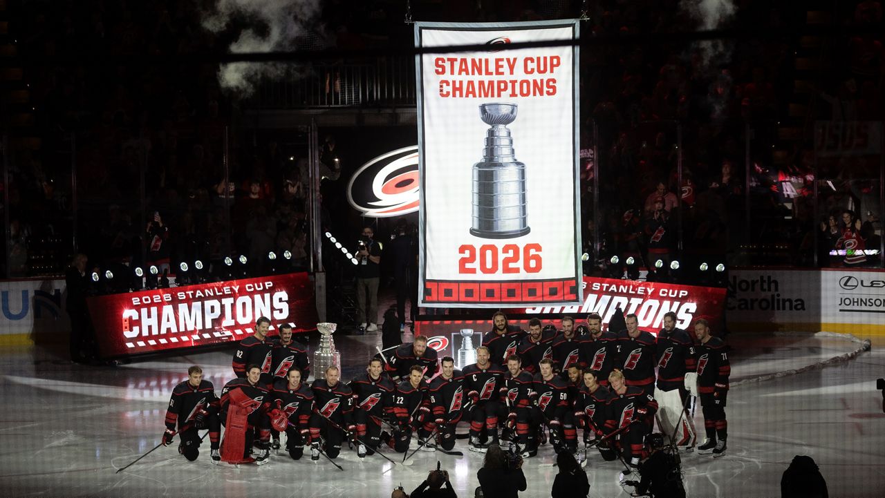 Carolina Hurricanes pose for a group photo as the championship banner is raised during the team's Stanley Cup celebration before their season-opening NHL hockey game against the Florida Panthers in Raleigh, N.C., Tuesday, Sept. 29, 2026. (AP Photo/Karl DeBlaker)