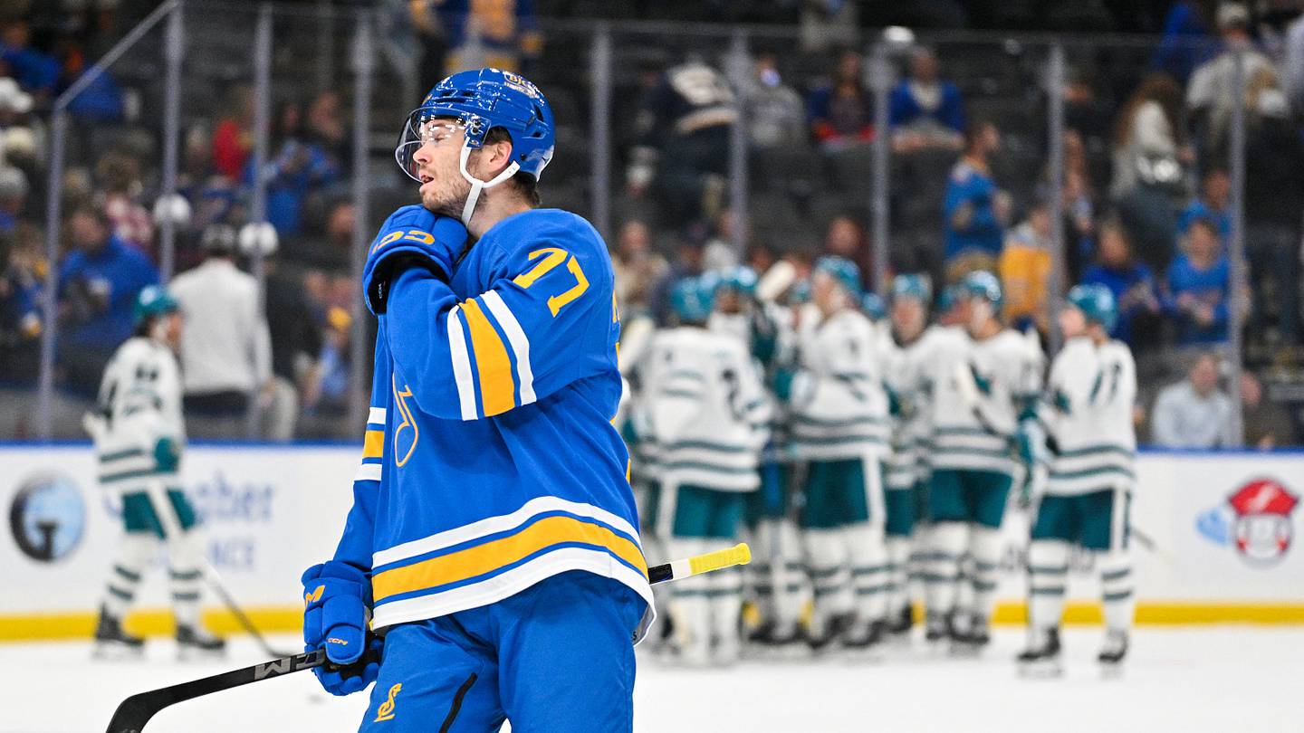 Oct 8, 2026; St. Louis, Missouri, USA; St. Louis Blues left wing Connor McMichael (77) looks on after San Jose Sharks defenseman Darnell Nurse (not pictured) celebrates with teammates after scoring the game winning goal in overtime at Enterprise Center. Mandatory Credit: Jeff Curry-Imagn Images