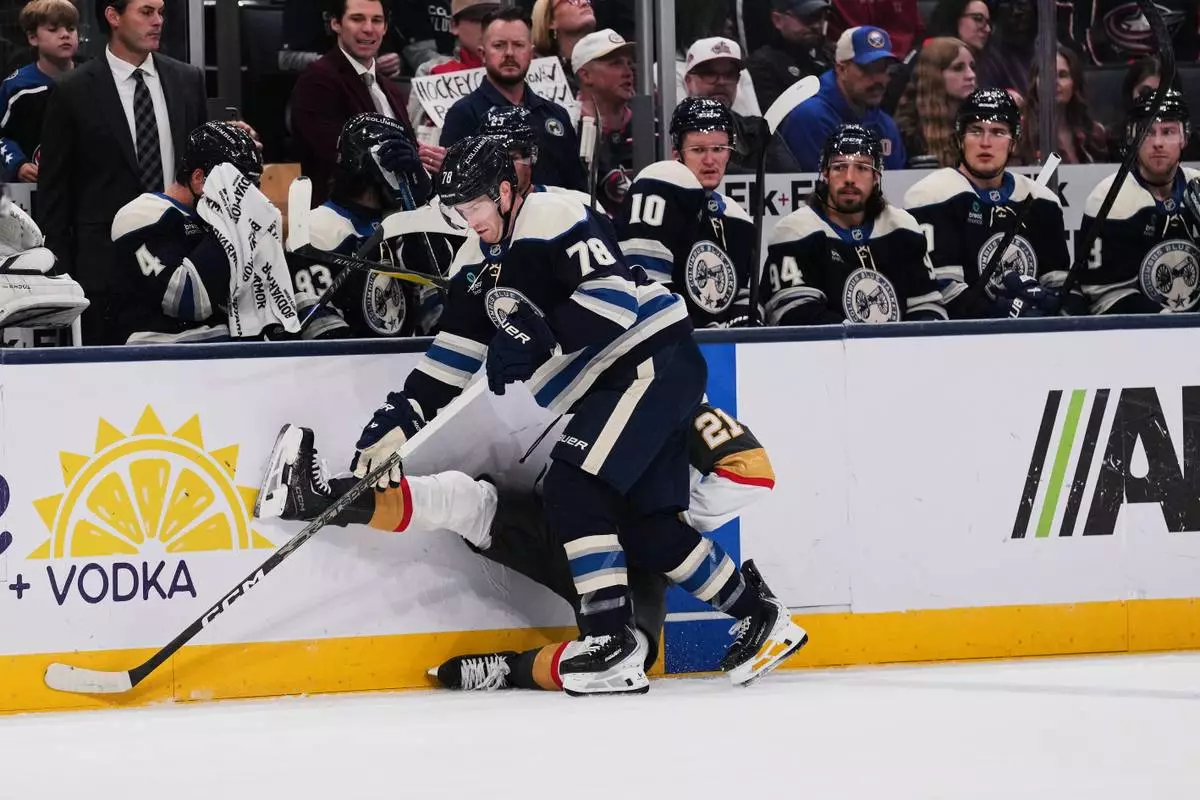 Columbus Blue Jackets defenseman Damon Severson (78) checks Vegas Golden Knights center Brett Howden (21) into the board during the second period of an NHL hockey game Saturday, Oct. 24, 2026, in Columbus, Ohio. (AP Photo/Joshua A. Bickel)