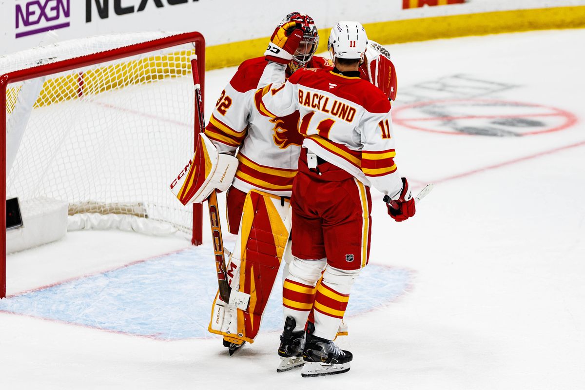 Mikael Backlund #11 of the Calgary Flames celebrates a win with Dustin Wolf #32 of the Calgary Flames after an NHL game against the Anaheim Ducks on October 13, 2026 at Honda Center in Anaheim, California. Mikael Backlund #11 of the Calgary Flames celebrates a win with Dustin Wolf #32 of the Calgary Flames after an NHL game against the Anaheim Ducks on October 13, 2026 at Honda Center in Anaheim, California.