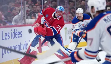 Montreal Canadiens goalie Jakub Dobes (75) clears the puck under pressure from Edmonton Oilers forward Zach Hyman (18) and forward Connor McDavid (97) during the third period at the Bell Centre.