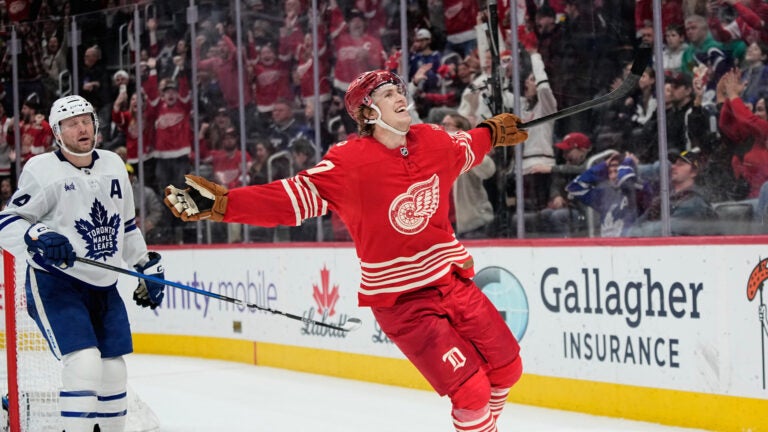 Detroit Red Wings defenseman Simon Edvinsson, right, celebrates near Toronto Maple Leafs defenseman Morgan Rielly, left, after scoring the winning goal during overtime of an NHL hockey game, Dec. 28, 2025, in Detroit.