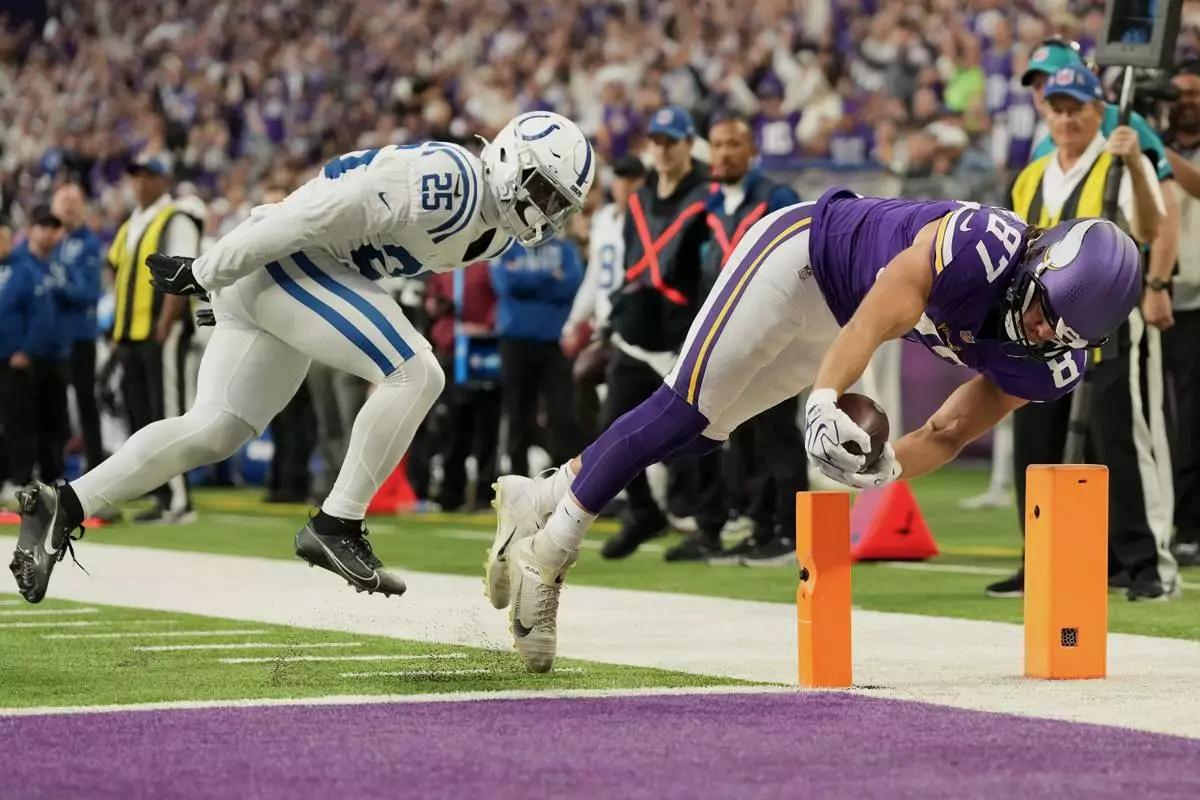 Minnesota Vikings tight end T.J. Hockenson (87) scores past Indianapolis Colts safety A.J. Haulcy (25) during the second half of an NFL football game in Minneapolis, Sunday, Oct. 25, 2026. (AP Photo/Ellen Schmidt)