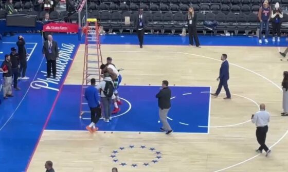 [dem389] Wells Fargo center crew working on rims after the game and Giannis pushes down ladder to practice FTs