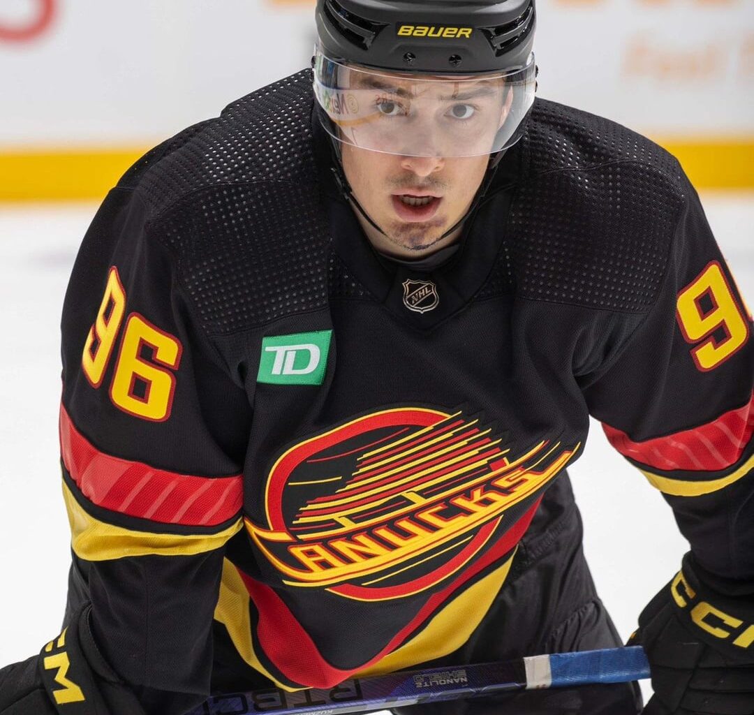 Canucks wearing matte black helmets with their retro jerseys