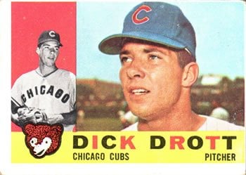April 24, 1957: Cubs pitcher Moe Drabowsky claims to be hit by a pitch, but the umpire isn't buying it. To help his case, rookie pitcher Dick Drott borrows a wheelchair from a fan to wheel Drabowsky to first base! The umpire is not amused.