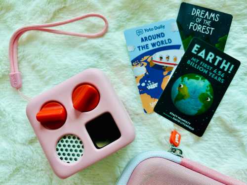 A pink audio player with orange knobs next to colorful cards titled "Around the World," "Dreams of the Forest," and "Earth!"