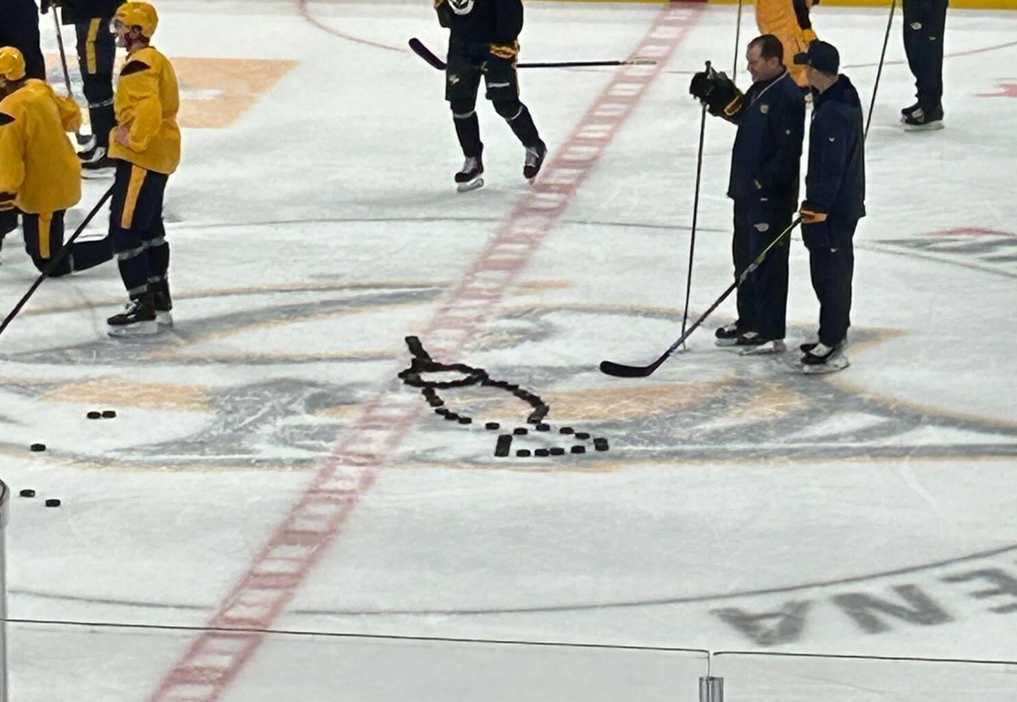 [Daugherty] Assistant coaches Todd Richards and Derek Mackenzie attempt to decipher the puck design someone made at center ice.