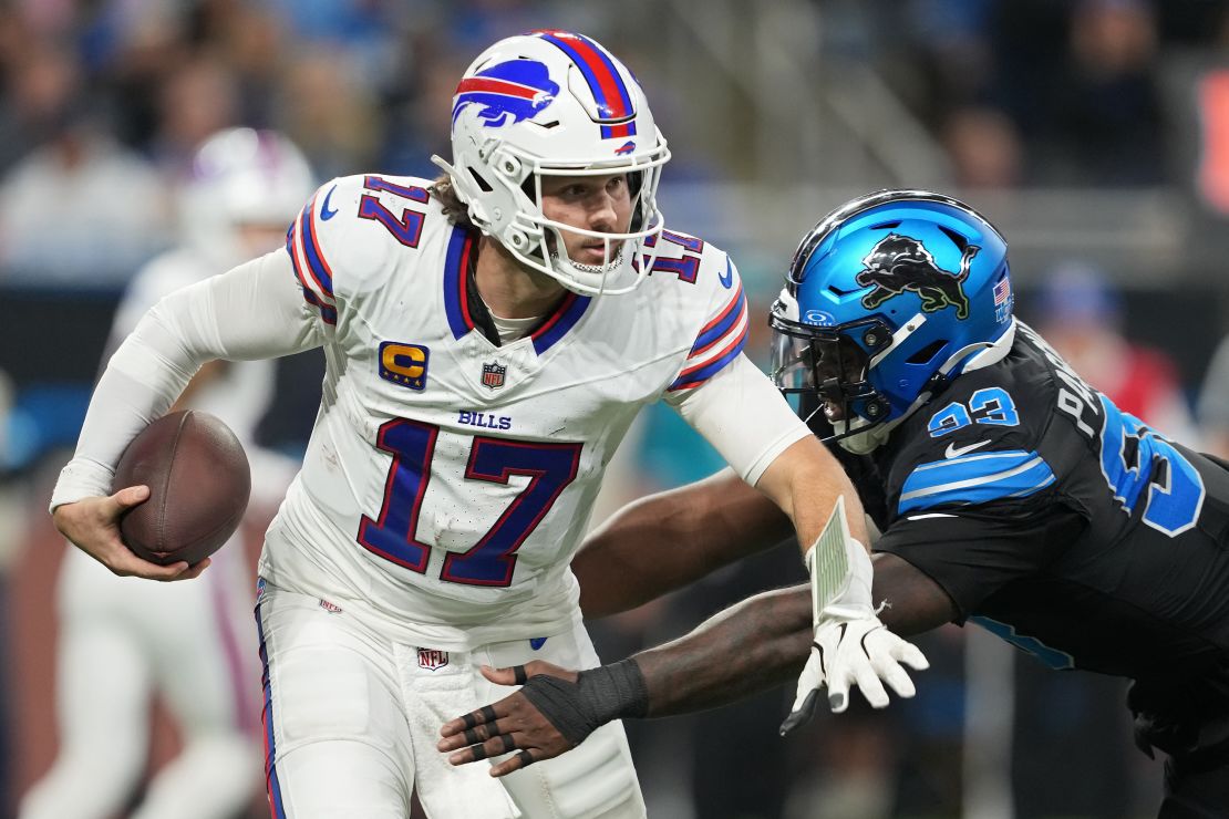 DETROIT, MICHIGAN - DECEMBER 15: Josh Allen #17 of the Buffalo Bills runs with the ball while being chased by Josh Paschal #93 of the Detroit Lions in the third quarter at Ford Field on December 15, 2024 in Detroit, Michigan. (Photo by Nic Antaya/Getty Images)