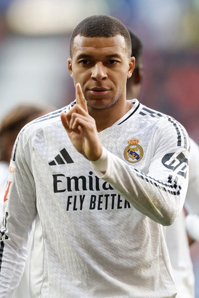 Kylian Mbappé in Real Madrid uniform celebrating a goal.