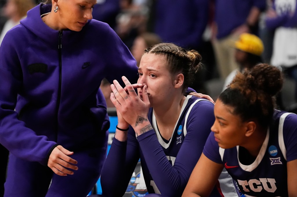 TCU center Sedona Prince, in purple uniform, reacting with her hands on her face after elimination from the NCAA Tournament
