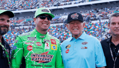 NASCAR Cup Series driver Kyle Busch (left center) and Joe Gibbs Racing owner Joe Gibbs (right center) in pit road prior to the start of the Coke Zero 400 at Daytona International Speedway.
