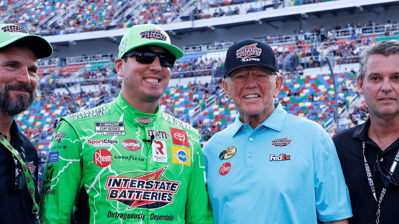 NASCAR Cup Series driver Kyle Busch (left center) and Joe Gibbs Racing owner Joe Gibbs (right center) in pit road prior to the start of the Coke Zero 400 at Daytona International Speedway.