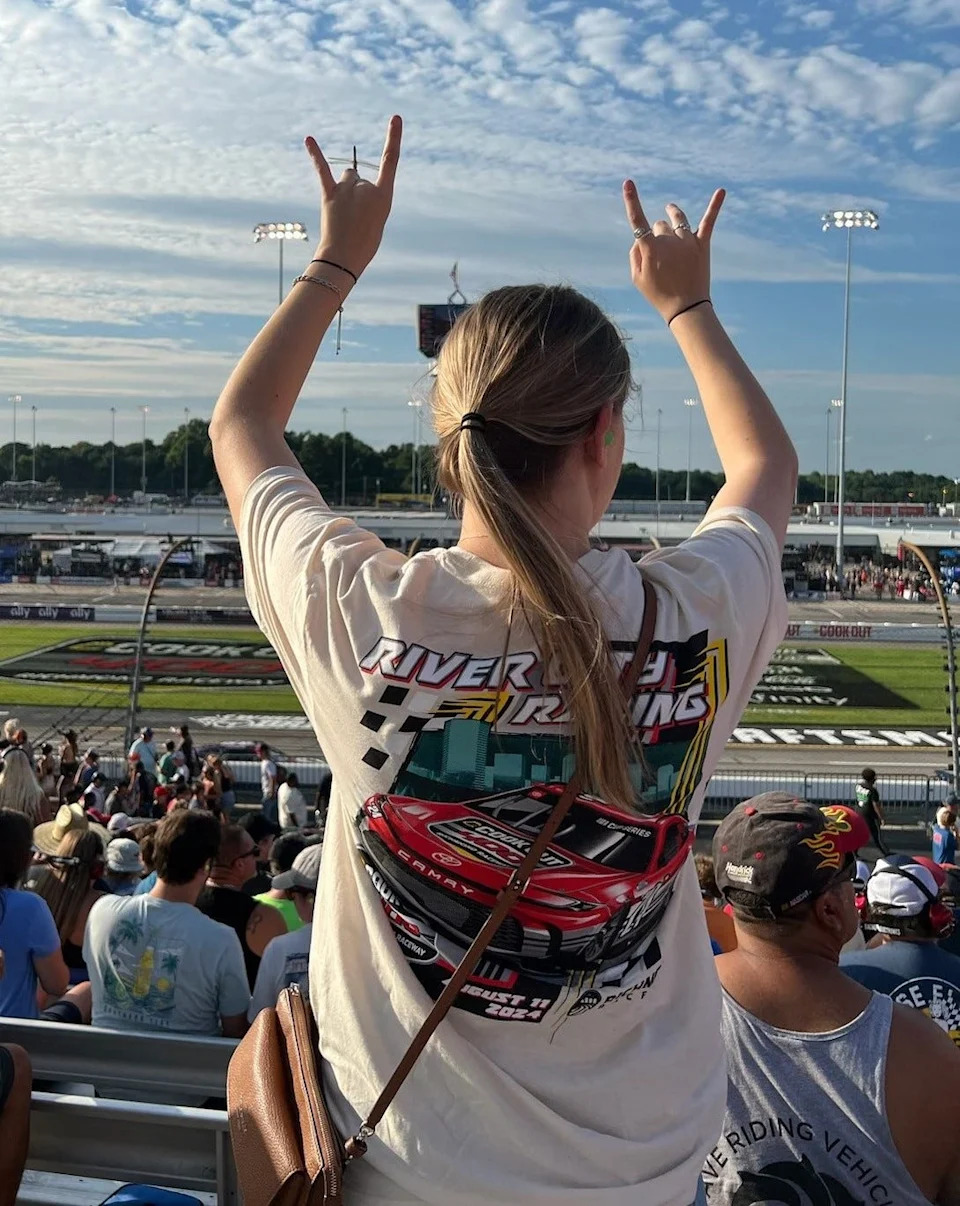 A dragonfly lands on Josie Bivins' finger at the NASCAR Cup Series Cook Out 400 at Richmond Raceway on Aug. 11, 2024.