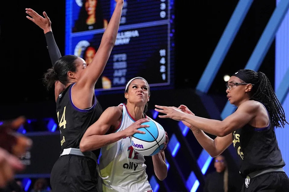 Vinyl wing Rae Burrell holds the ball and tries to split between Owls forward Napheesa Collier and wing Allisha Gray