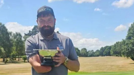 Mark Marshall with the one-armed golf World Championship trophy 