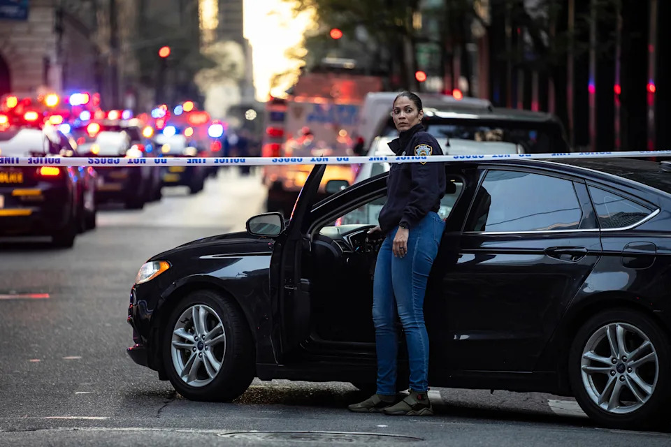 A New York police investigator exits her vehicle at the scene of Monday's shooting in New York City that left five dead, including the shooter.