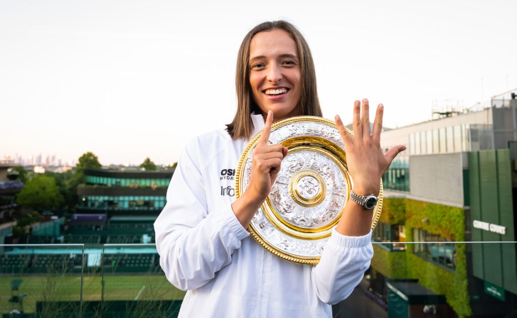 Iga Swiatek of Poland poses with six fingers representing her six Grand Slam wins after defeating Amanda Anisimova in the 2025 Wimbledon final