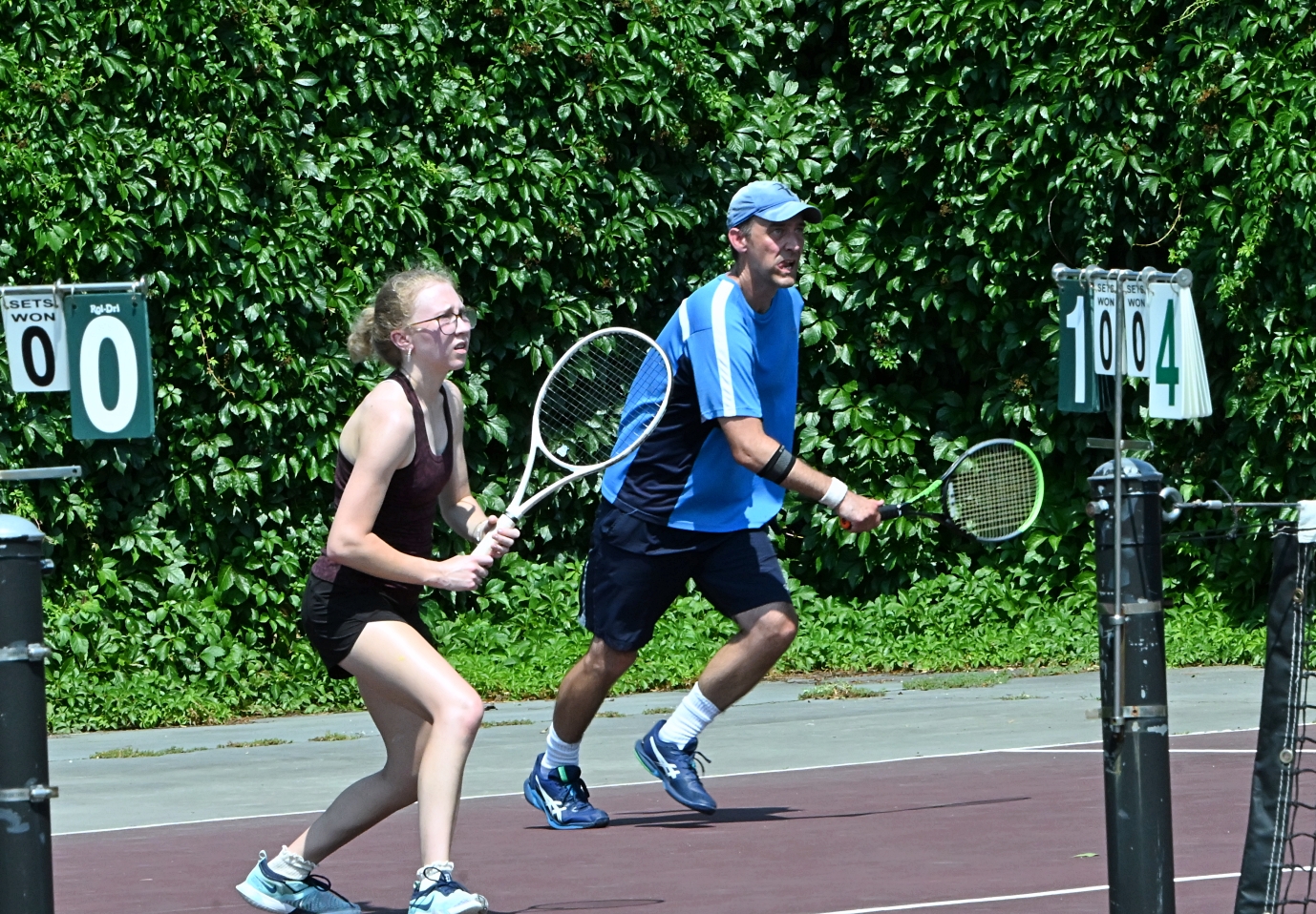Alice Vogel and her dad John rush the net during their mixed doubles match Saturday, July 26 in the Hub City Open on the Northern State courts. Aberdeen Insider photo by Robb Garofalo.