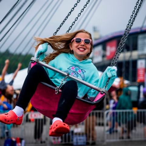A young race fan enjoys a carnival ride in New Hampshire Motor Speedway’s Fan Zone on June 23, 2024.