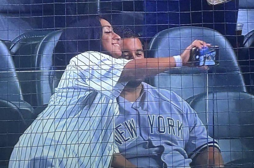 A Yankees fan trying to get a selfie with her distraught boyfriend immediately after New York was walked off by the Texas Rangers