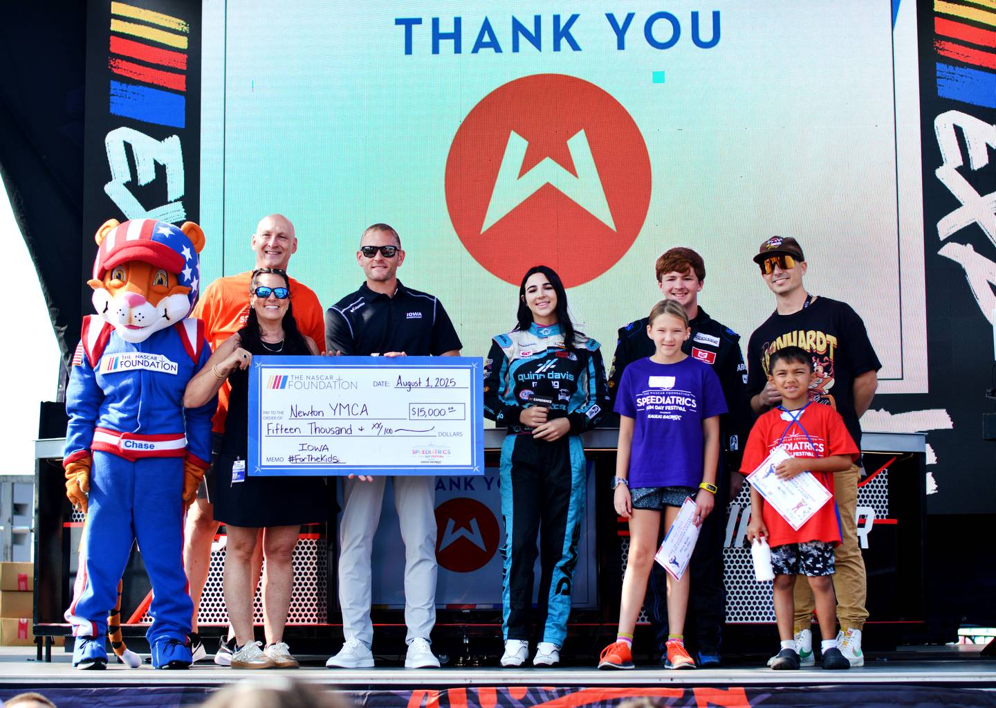 Newton YMCA accepts a donation during the Speediatrics Fun Day Festival activities Friday, Aug. 1 at the Iowa Speedway.