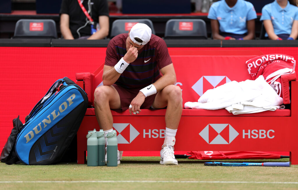 Jack Draper looks dejected, sat on his bench