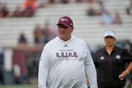 Texas A&M head coach Mike Elko watches players warm up before an NCAA college football game...