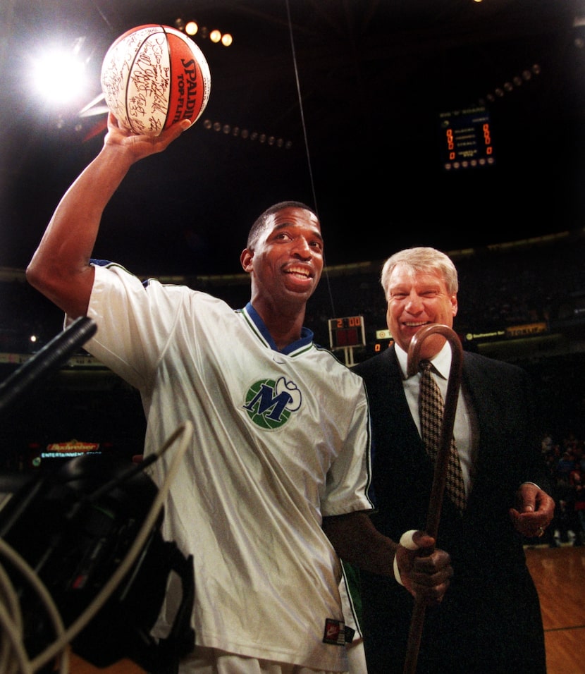 NBA Iron Man A.C. Green holds up an autographed game ball and walks with a cane given to him...