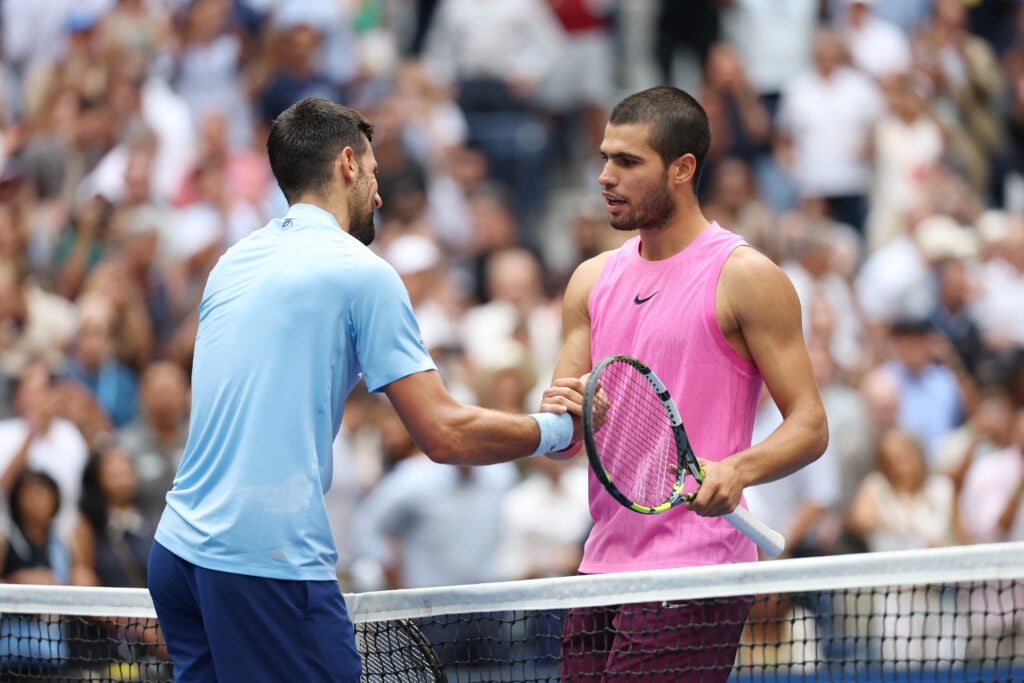 Carlos Alcaraz and Novak Djokovic meet at the net after their semifinal clash at the US Open.