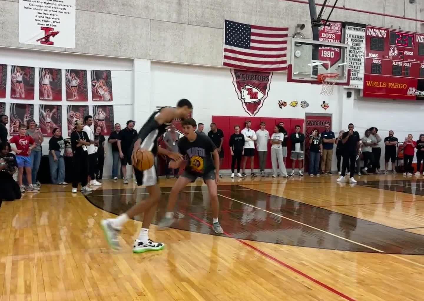 Victor Wembanyama blocks a fan and then dunks on him.